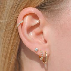 a close up of a person's ear with two different types of earrings on it