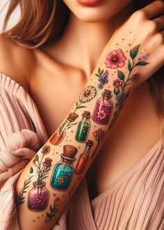 a woman's arm with tattoos on it and flowers in the jars behind her