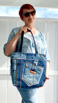 a woman is holding a blue jean purse