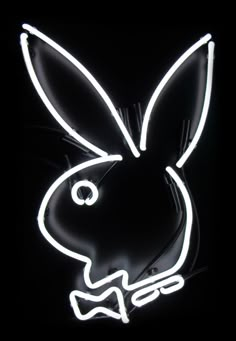 a neon rabbit head with a bow tie on it's head is lit up in the dark