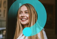 a woman with long blonde hair smiling in front of a blue and green circular frame