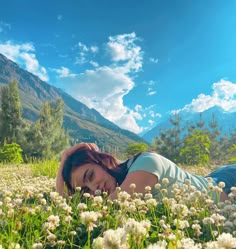 a woman laying in the grass with her eyes closed