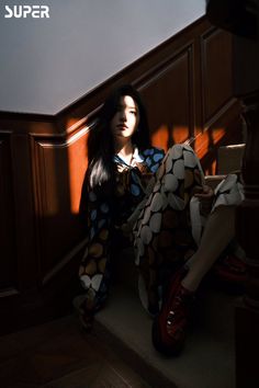 a woman is sitting on the stairs with her legs crossed