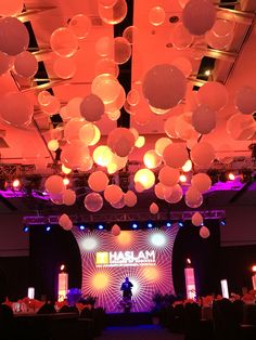 a large room filled with lots of lights and balloons hanging from the ceiling above it