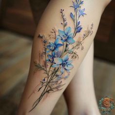 a woman's thigh with blue flowers on it and the bottom half of her leg