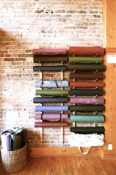 a wall mounted yoga mat rack in front of a brick wall