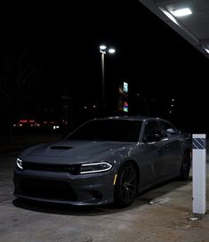 a gray dodge charger parked at a gas station