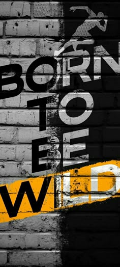 a brick wall with the words born to be wild painted on it in black and yellow