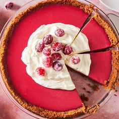 there is a pie with cream and raspberries on the top, ready to be eaten