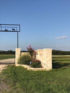 there is a dog that is sitting on the top of a sign in front of a gate