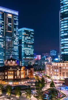 the city is lit up at night with skyscrapers in the background