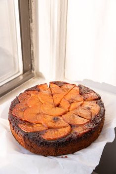 a cake sitting on top of a piece of paper next to a window sill