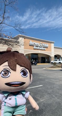 a stuffed doll sitting in front of a store