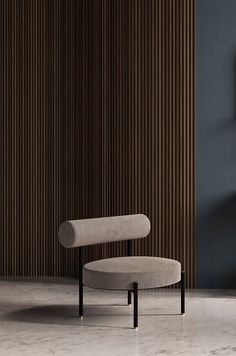 a chair sitting on top of a marble floor next to a wall with wooden slats