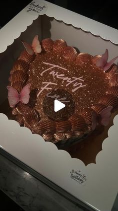 a cake in a box with pink butterflies on it