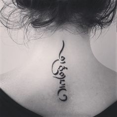 the back of a woman's neck has a tattoo on it that reads,