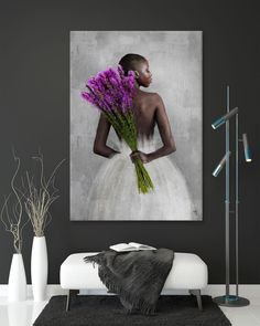 a woman in a white dress with purple flowers on her back, holding a bouquet