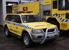 two yellow emergency vehicles parked next to each other