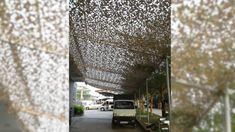 a white van parked under a canopy covered in lots of small birds on the ceiling