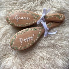 three wooden spoons with writing on them are sitting on a white furnishing