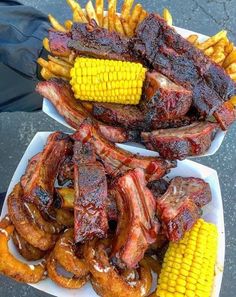 two trays filled with ribs, corn on the cob and sweetcorn