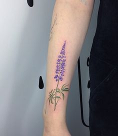 a woman's arm with a purple flower tattoo on it