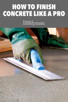 a person in green gloves is using a trowel to finish concrete like a pro