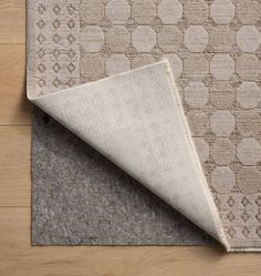 an area rug on the floor with a white and beige carpeting pattern in the middle