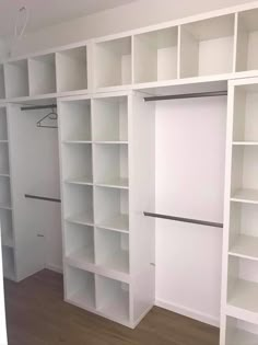 an empty room with white bookcases and wooden floors