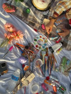 the table is covered with art supplies such as paint, brushes, and other things