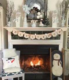 a fireplace decorated with snowmen and stockings