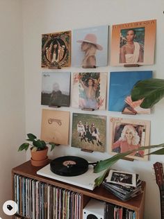 a record player sitting on top of a wooden shelf next to a wall filled with records