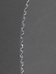 a close up view of the back side of a mesh curtain with beads on it