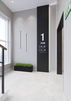 the entrance to a modern office building with grass on the floor