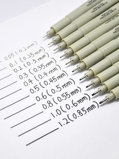 several pens are lined up on top of a sheet of paper with numbers and times