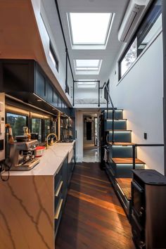 a long narrow kitchen with skylights above the counter and stairs leading up to the second floor