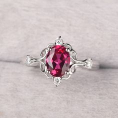 a close up of a ring with a pink stone in the middle and white diamonds around it