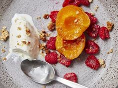 an ice cream sundae with fruit and granola on the side is ready to be eaten