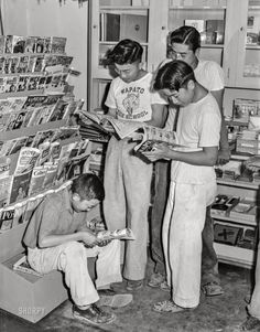 black and white photograph of people looking at magazines