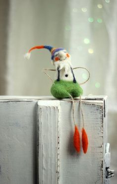 a small stuffed animal sitting on top of a wooden cabinet