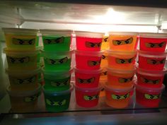 many plastic cups with different colored lids are lined up in front of a refrigerator door