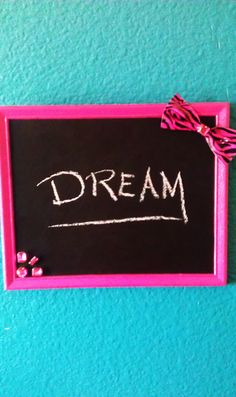 a chalkboard with the word dream written on it and a pink bow tied to it