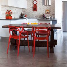 a kitchen with red chairs and a wooden table