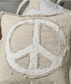 a peace sign pillow sitting on top of a bed