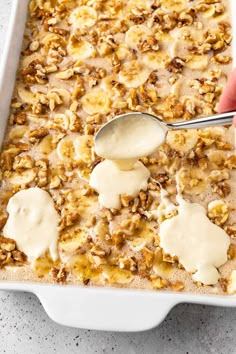 a spoon is being used to scoop some food out of the casserole dish