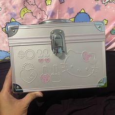 a hello kitty suitcase is being held up by someone's hand with the lid open