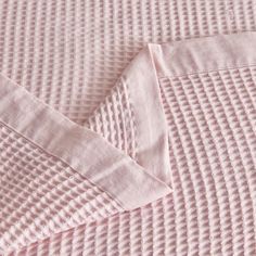 closeup of pink bed linens with white stitching on the top and bottom