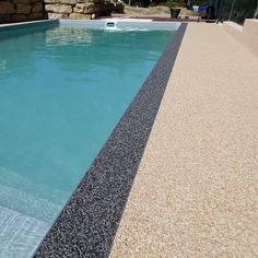 an empty swimming pool surrounded by rocks and gravel