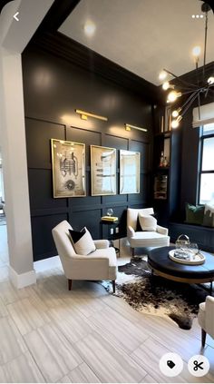 a living room with black walls and white furniture