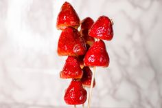 strawberries are arranged on toothpicks in the shape of heart shaped lollipops